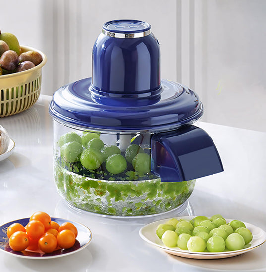 Electric peeler tool on a kitchen counter with freshly peeled fruits and vegetables and prep ingredients.